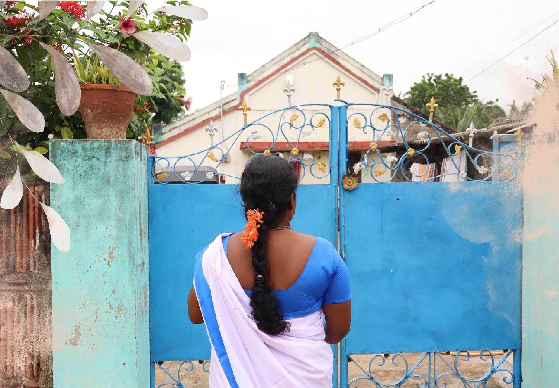 Krishnaveni walking through Yanamadla village, seen from behind approaching a household