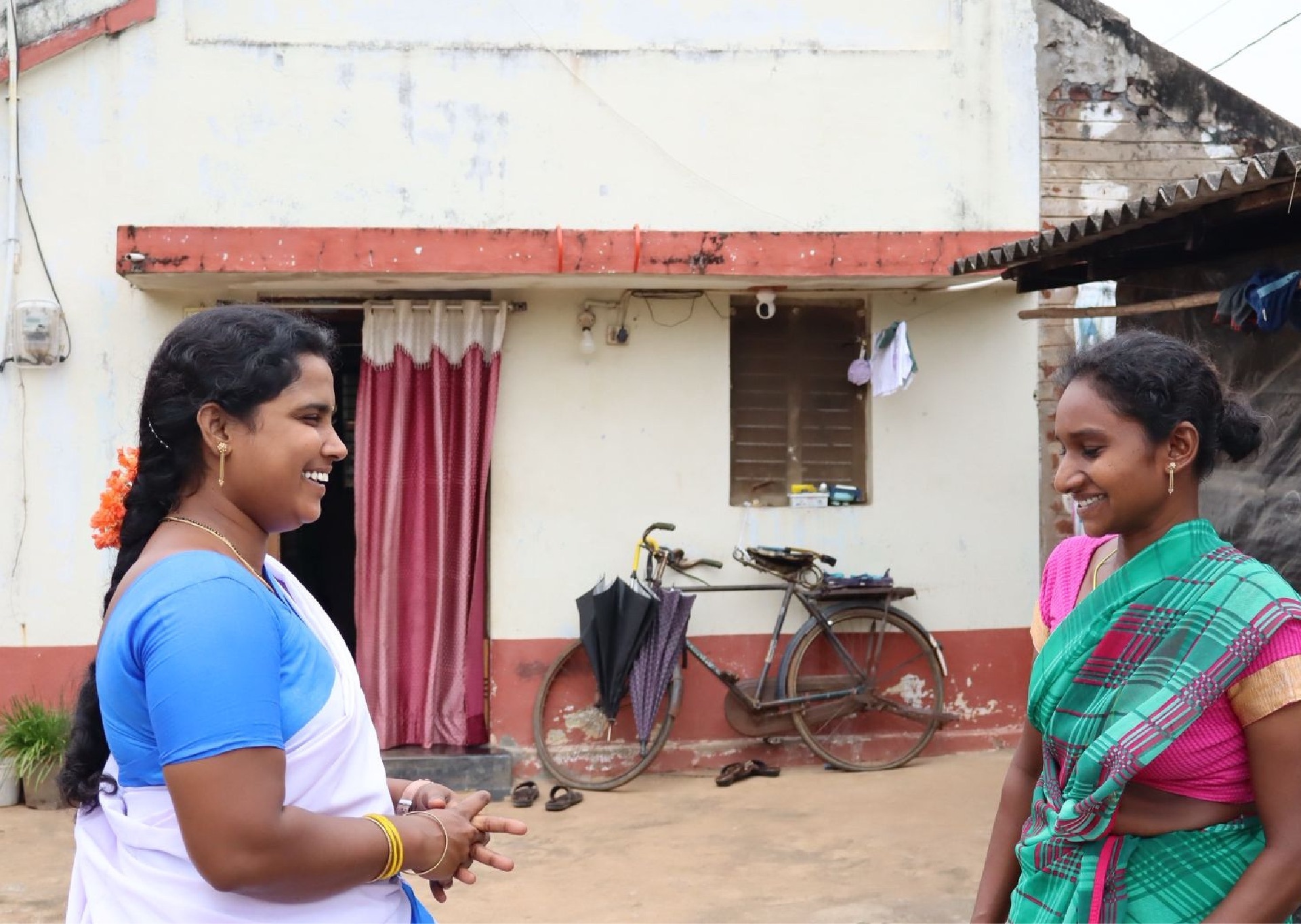 Krishnaveni speaking with a young mother during a home visit in Yanamadla village