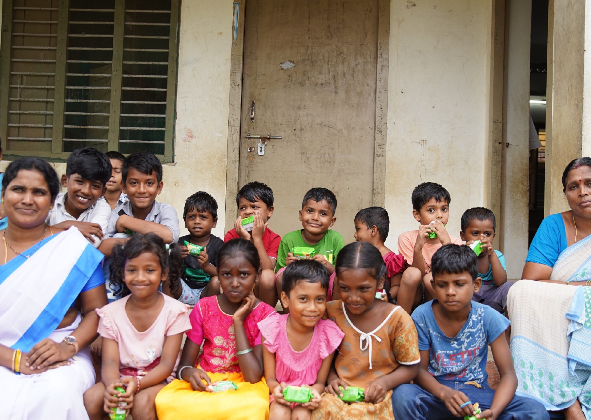 Children and families gathered in Yanamadla village, smiling, with Krishnaveni among them